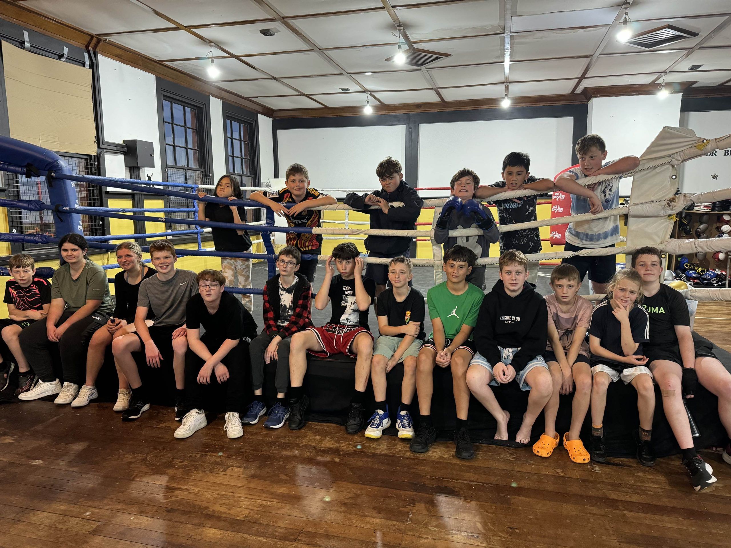 Rangatahi sitting along the ring apron together at the EP Fitness and Wellbeing Hub.